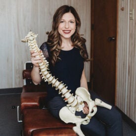 Dr. Melissa Birdsell holding spine model.