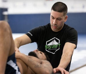 Dr. Camacho working with client lying on mat.