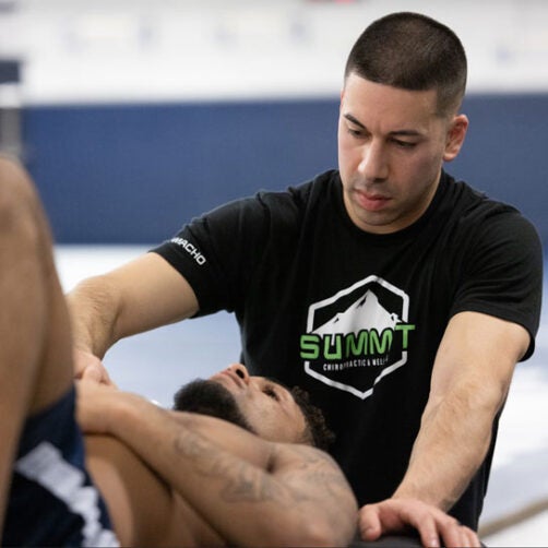 Dr. Camacho working with client lying on mat.