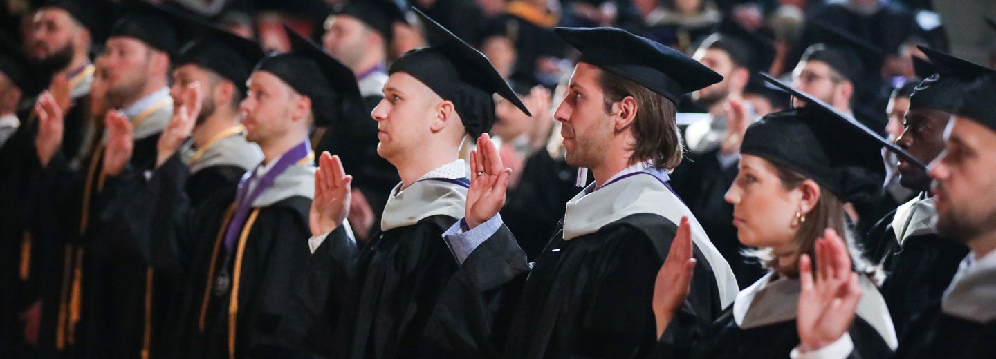 Row of students in graduation cap and gowns.