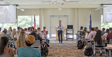 Dr. Sherrier presents to a large group of seated people.