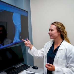 Student Samantha Schumacher pointing at X-ray.