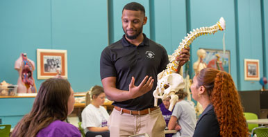 Instructor showing spine model to students.