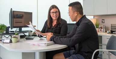 Student and counselor sitting at desk.