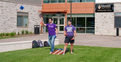 Students playing bags outside VanDuyne Hall