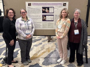 Poster presenters standing next to their poster.