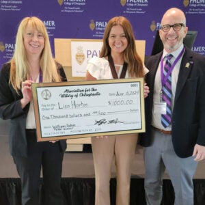 Lisa Horton standing with faculty holding large check.