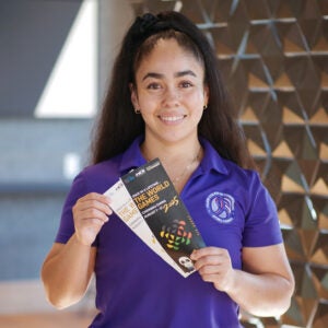 Leslie Castillo-Ortiz holding World Games brochures.