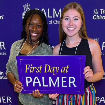 Two students with First Day at Palmer poster.