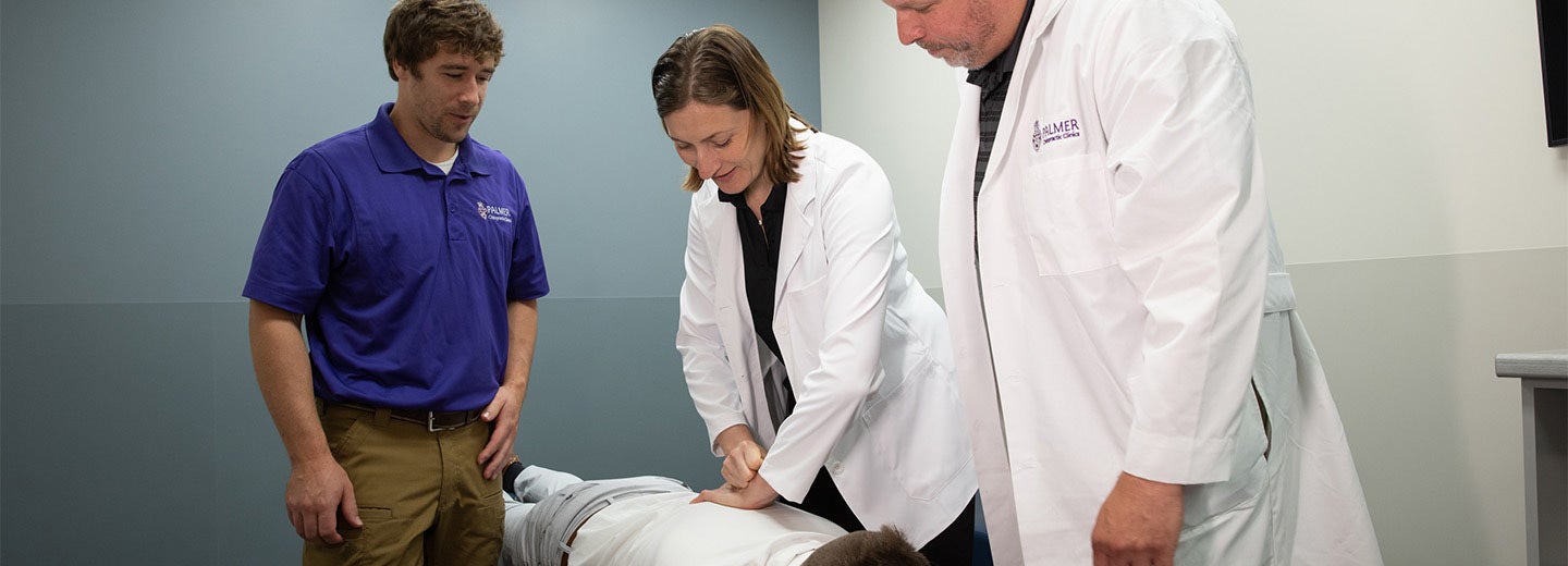 Two clinicians and student with patient.