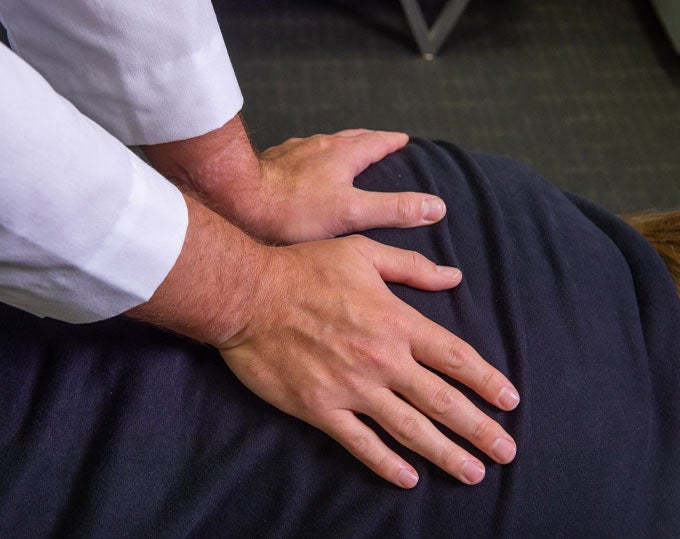 Hands on patient's back.