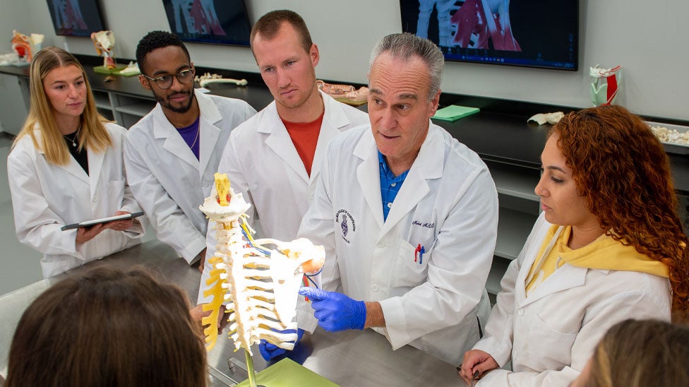 Instructor using spine model to teach students.