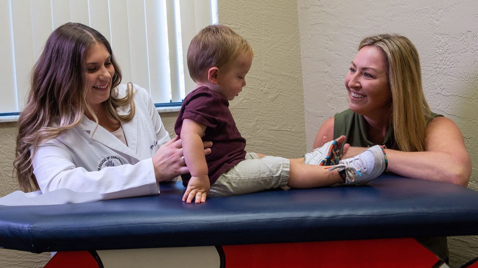Clinician and intern with pediatric patient.