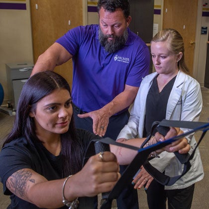 Rehab clinician with intern and patient.