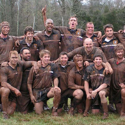Men's muddy rugby match group photo.
