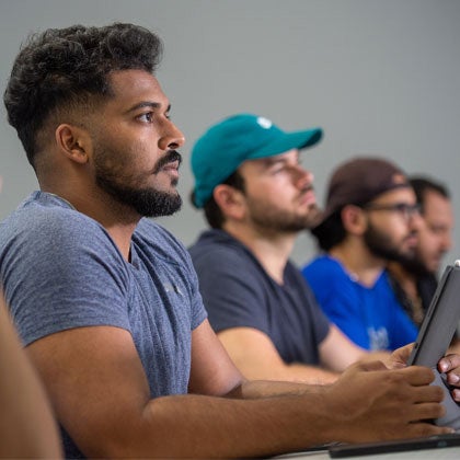 Students listening to lecture holding iPads.