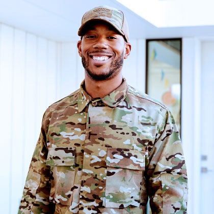 Man in military uniform smiling.
