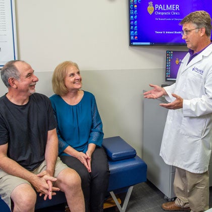 Clinician speaking to older couple.