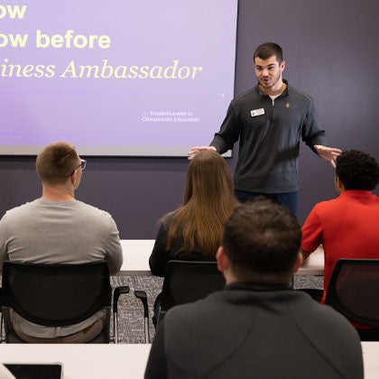 PCBD presenter speaking to group of students.