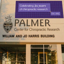 Palmer Center for Chiropractic's William and Jo Harris Building with 30 year anniversary banner.
