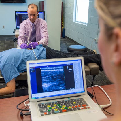 Dr. Vining doing an ultrasound on patient's back.
